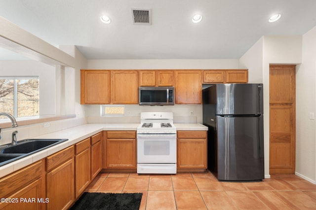 kitchen featuring light tile patterned flooring, appliances with stainless steel finishes, and sink