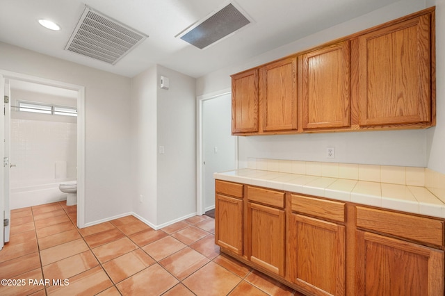 kitchen with tile countertops and light tile patterned floors