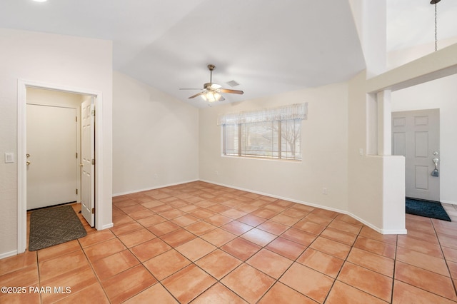 spare room with ceiling fan, lofted ceiling, and light tile patterned floors