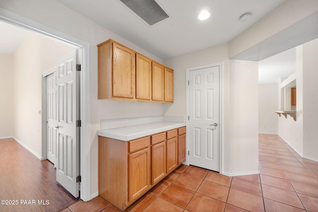 kitchen featuring light tile patterned floors and light brown cabinetry