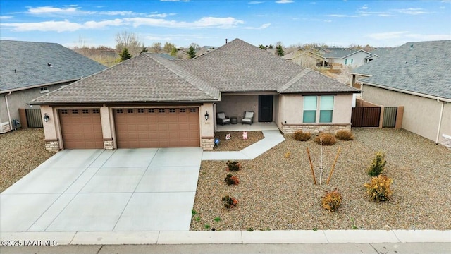 ranch-style home with fence, stucco siding, concrete driveway, a garage, and stone siding