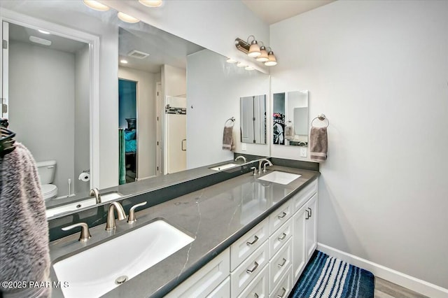 bathroom with a sink, baseboards, and toilet