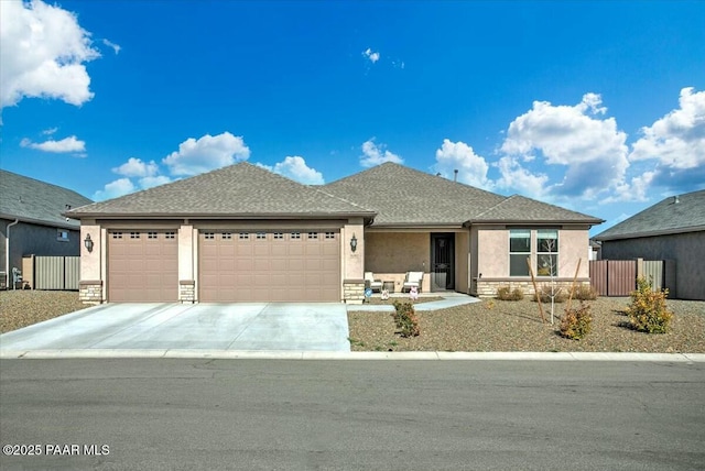 view of front facade featuring stucco siding, stone siding, a garage, and concrete driveway