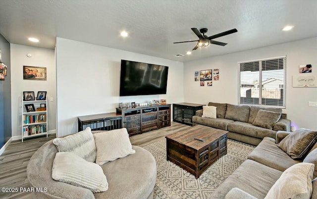 living room with a ceiling fan, recessed lighting, and wood finished floors