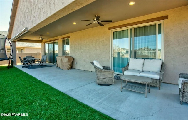 view of patio / terrace featuring a ceiling fan, a trampoline, fence, a grill, and an outdoor hangout area