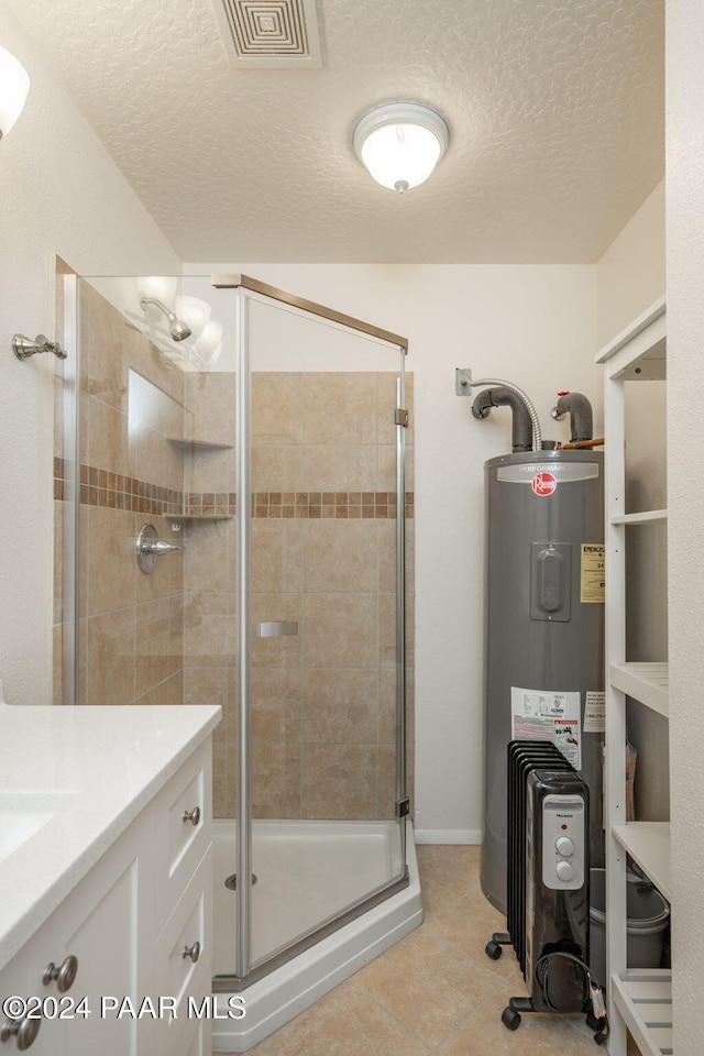 bathroom with tile patterned floors, an enclosed shower, a textured ceiling, vanity, and water heater