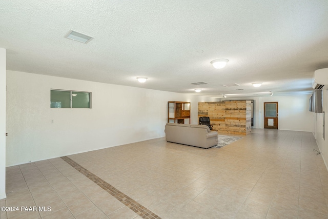 unfurnished living room with an AC wall unit and light tile patterned flooring