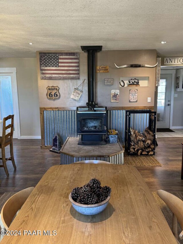 living room featuring a textured ceiling, hardwood / wood-style flooring, and a wood stove