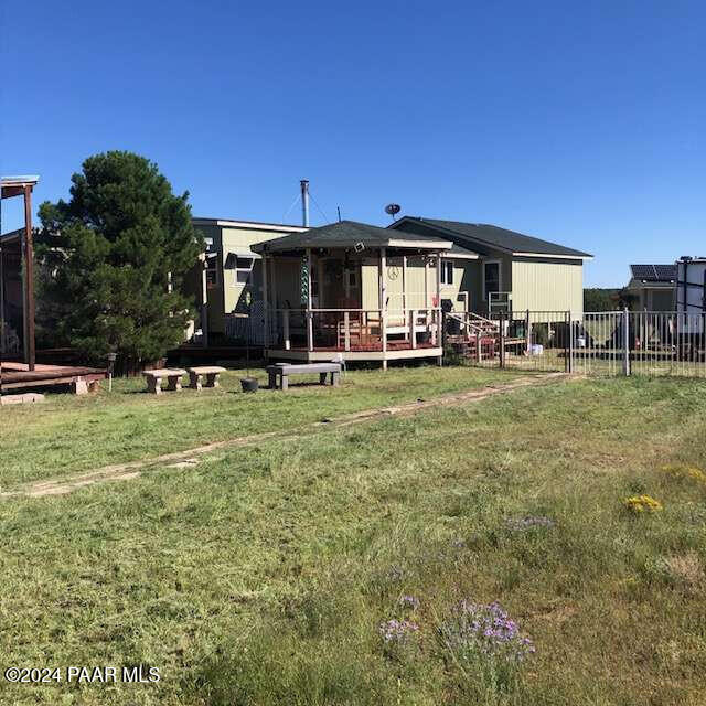 back of house featuring a wooden deck and a yard