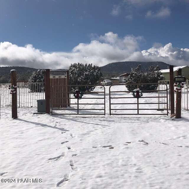 snow covered gate with a mountain view