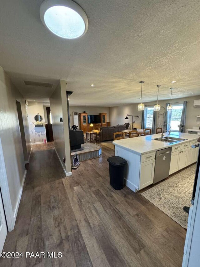 kitchen featuring white cabinets, a kitchen island with sink, sink, dishwasher, and dark hardwood / wood-style floors