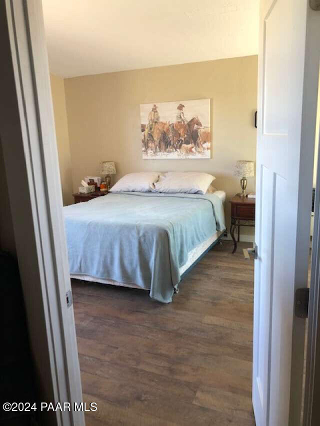 bedroom with dark hardwood / wood-style floors