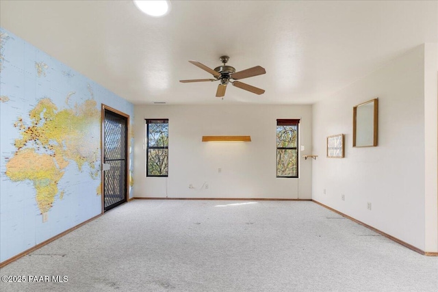 carpeted spare room with ceiling fan