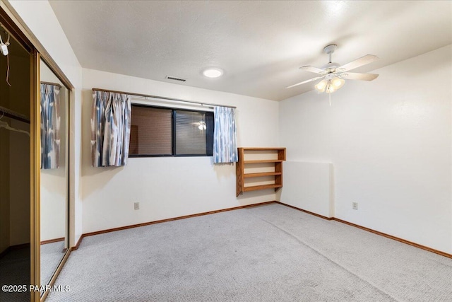 unfurnished room featuring carpet flooring, a textured ceiling, and ceiling fan