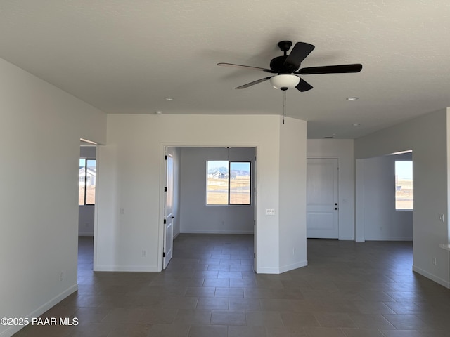 tiled spare room with a textured ceiling, a wealth of natural light, and ceiling fan