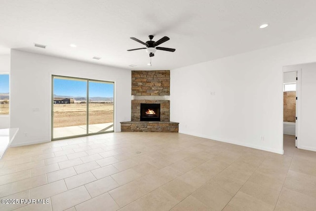 unfurnished living room featuring visible vents, baseboards, ceiling fan, a stone fireplace, and recessed lighting