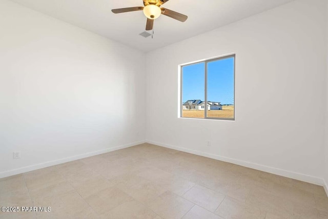 empty room with a ceiling fan and baseboards