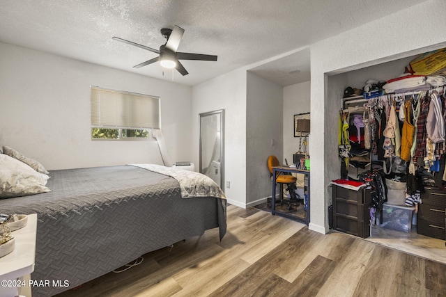 bedroom with ceiling fan, a closet, light hardwood / wood-style floors, and a textured ceiling