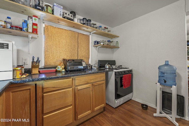 kitchen with dark hardwood / wood-style floors and stainless steel range with gas stovetop