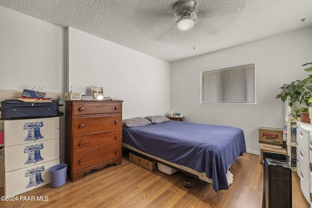 bedroom with ceiling fan, a textured ceiling, and light hardwood / wood-style flooring