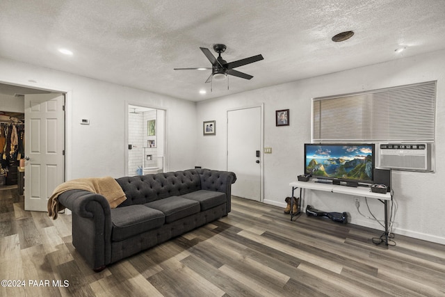 living room with ceiling fan, dark hardwood / wood-style flooring, and a textured ceiling