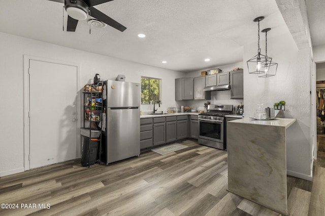 kitchen with decorative light fixtures, sink, dark wood-type flooring, and appliances with stainless steel finishes