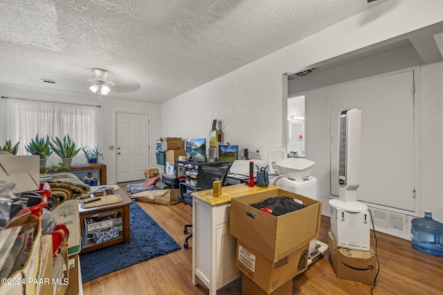 interior space with ceiling fan, light hardwood / wood-style flooring, and a textured ceiling