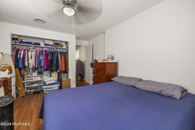 bedroom featuring a textured ceiling, ceiling fan, a closet, and dark hardwood / wood-style floors