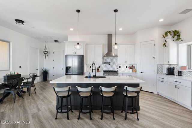 1232 Jordin Dr, Prescott, AZ 86303 - kitchen with stainless steel refrigerator with ice dispenser, wall chimney exhaust hood, sink, a kitchen island with sink, and white cabinets