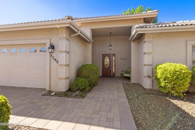 property entrance featuring a garage and stucco siding