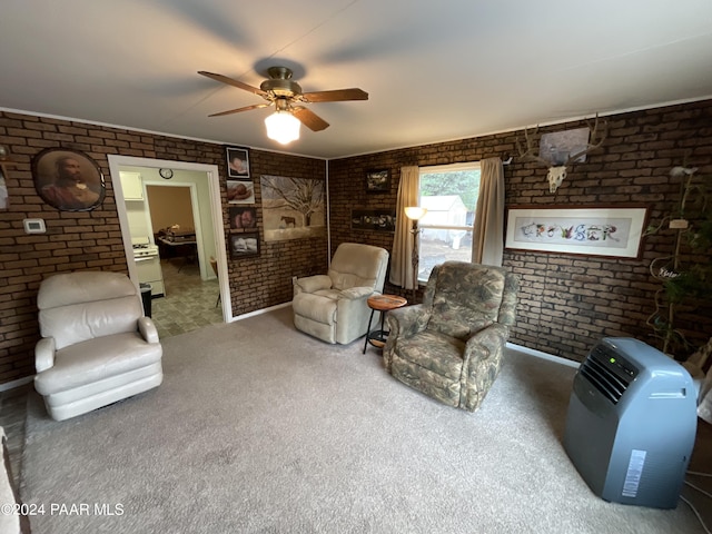 living room featuring carpet flooring, ceiling fan, and brick wall