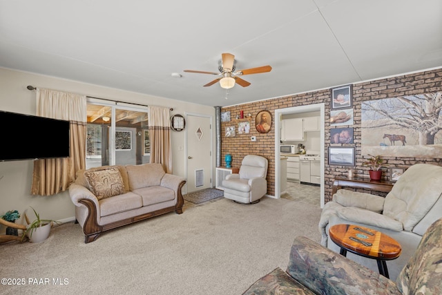 living area with light carpet, ceiling fan, and brick wall