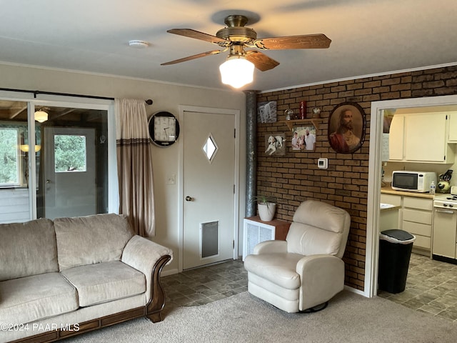 living room featuring carpet, ceiling fan, ornamental molding, and brick wall