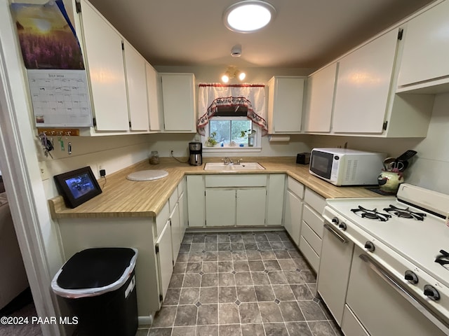 kitchen featuring white cabinets, white appliances, and sink