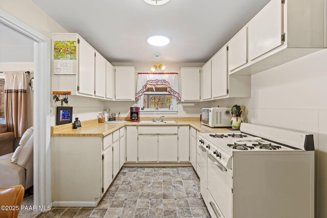 kitchen featuring white cabinetry, a wealth of natural light, and white appliances