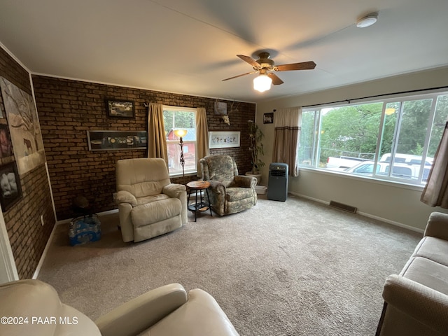 carpeted living room featuring ceiling fan and brick wall