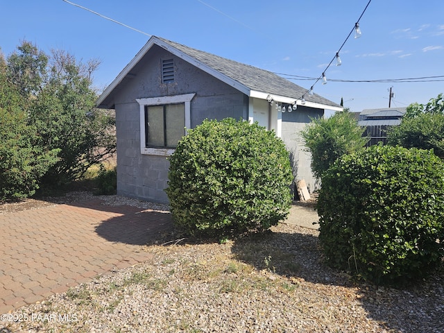 3916 N Catherine Dr, Prescott Valley, AZ 86314 - view of side of property with concrete block siding, a shingled roof, and a patio