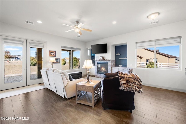 living room featuring dark hardwood / wood-style floors, ceiling fan, a fireplace, and french doors