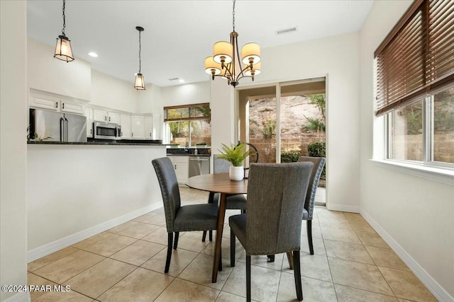 dining space with light tile patterned floors and a notable chandelier