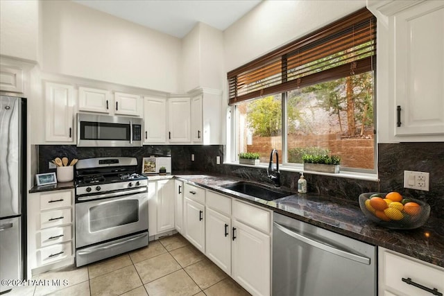 kitchen with white cabinets, sink, appliances with stainless steel finishes, and tasteful backsplash