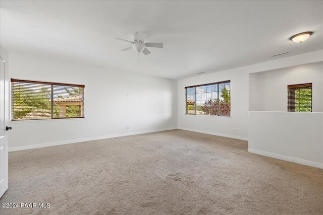 carpeted spare room featuring ceiling fan