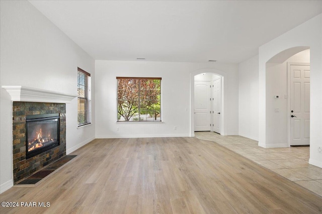 unfurnished living room with a fireplace and light hardwood / wood-style flooring