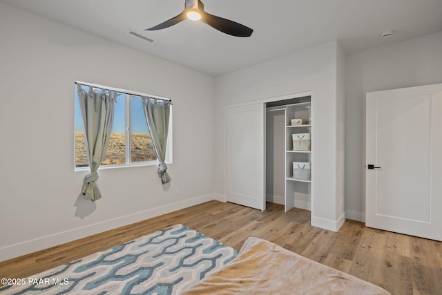 bedroom with ceiling fan, light wood-type flooring, and a closet