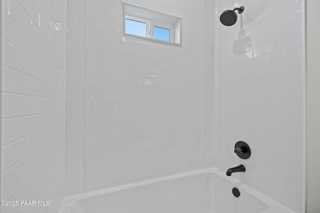 interior details with tiled shower / bath combo