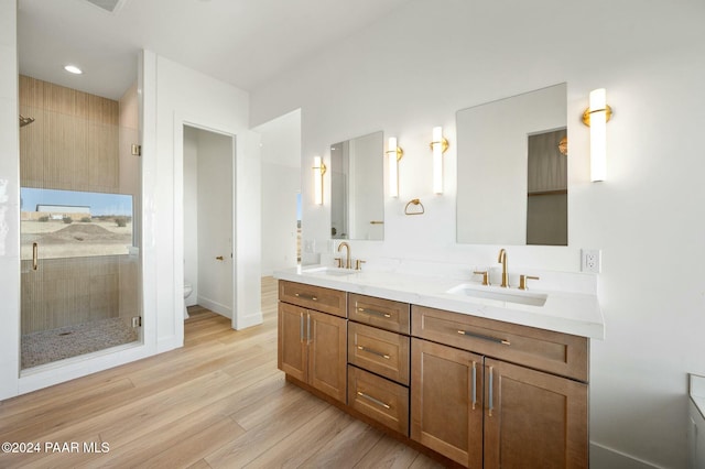 bathroom featuring vanity, toilet, wood-type flooring, and a shower with shower door