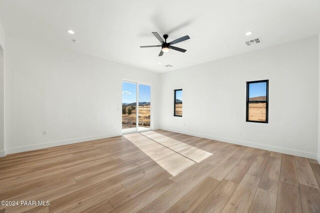 empty room featuring ceiling fan and light hardwood / wood-style flooring