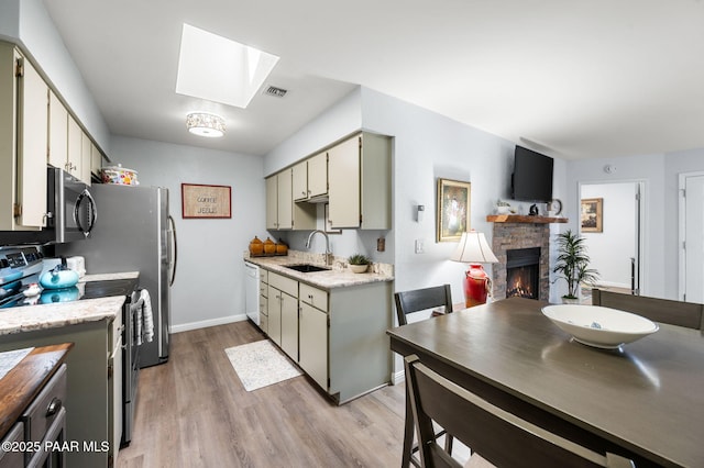 3168 Dome Rock Pl Unit 16F, Prescott, AZ 86301 - kitchen featuring a skylight, a fireplace, stainless steel electric stove, light wood-style flooring, and light countertops