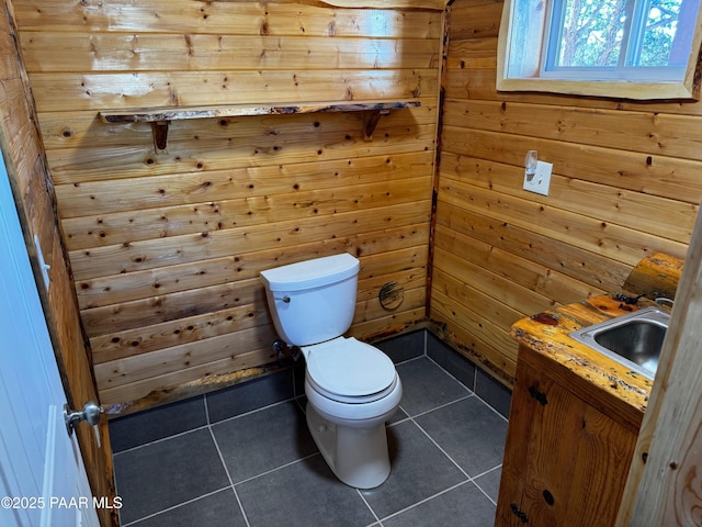 bathroom with wood walls, tile patterned flooring, vanity, and toilet