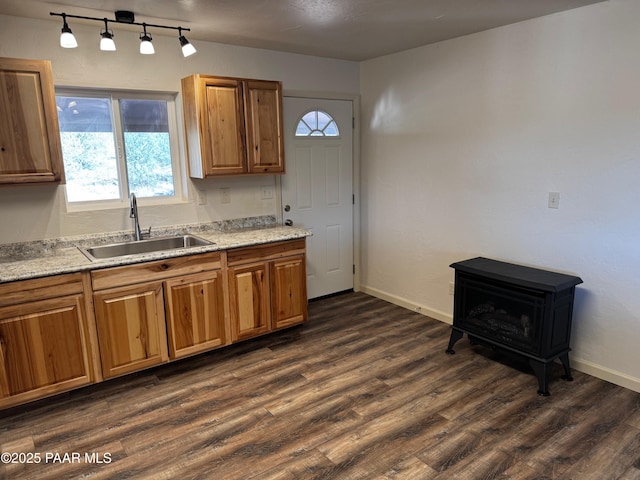 kitchen with sink, dark wood-type flooring, and light stone counters