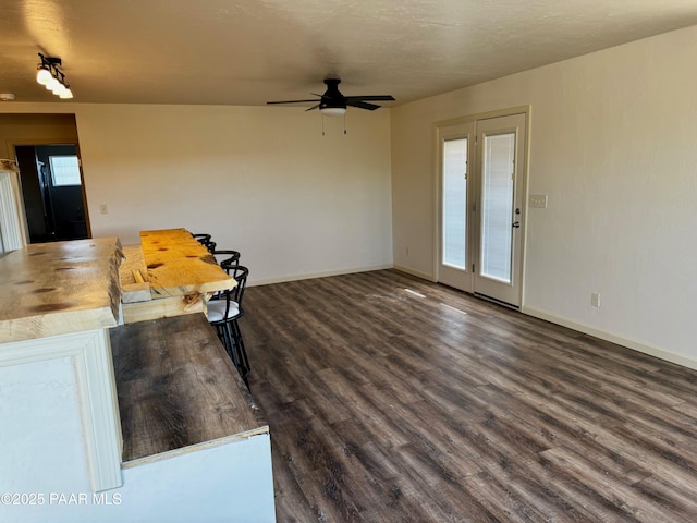 interior space with dark wood-type flooring and ceiling fan